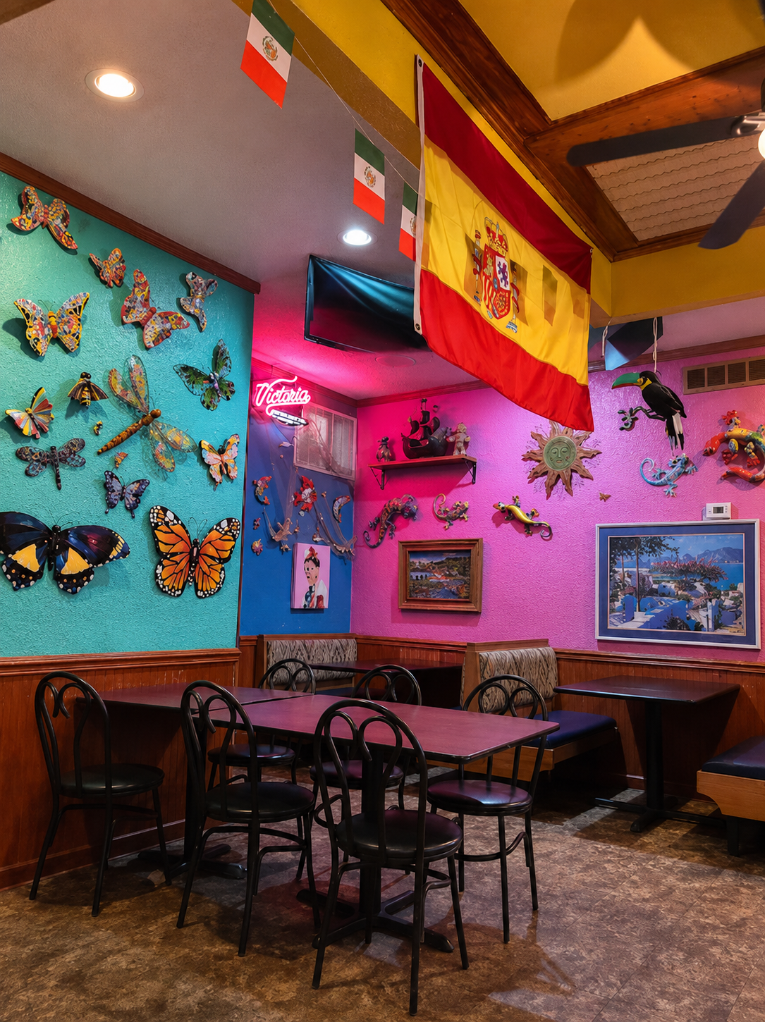 Colorful interior dining room at Maracas Mexican Restaurant with flags and butterfly art on the walls